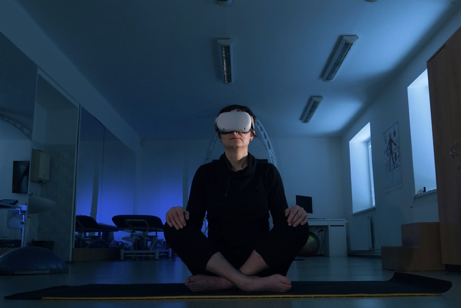 Človek sediaci v tureckom sede s virtuálnym headsetom na hlave